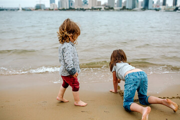 Brother and sister playing in sand on beach