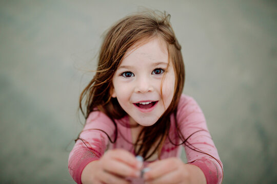 Soaked smiling girl holding seashells