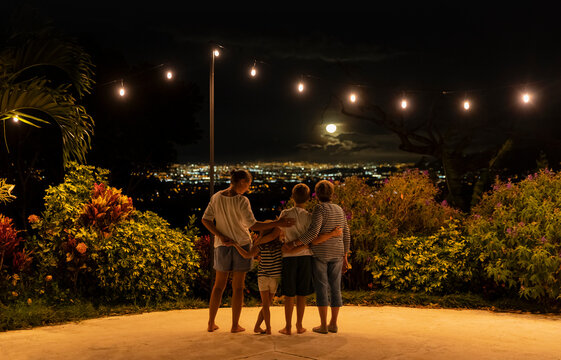 Family together watching moonrise over city