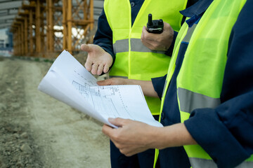 Hands of male builder explaining sketch to female colleague at working meeting