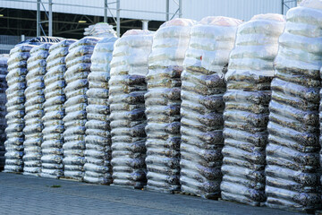 Pallets stacked with large transparent plastic film bags of soil peat