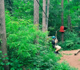 Kid in a blue helmet on a sliding swing. Agility skills and climbing outdoor amusement center for children. Agility skills and climbing outdoor amusement center for children. Young boy plays outdoors