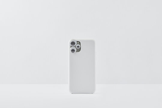 White smartphone with toy eyes on camera