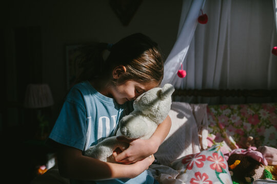 child affectionately holds stuffed animal 