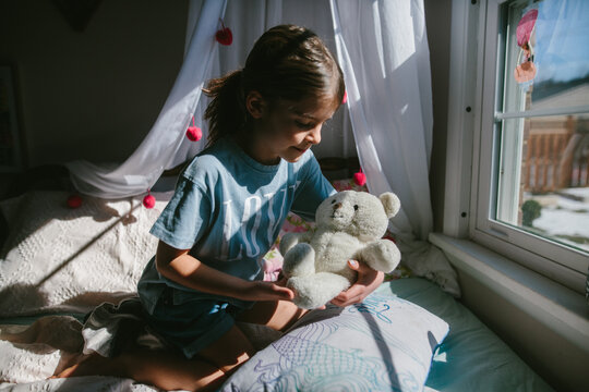 child affectionately holds stuffed animal 