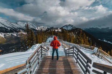 Foto op Canvas A man with a red jacket looking at the Canadian Rockie mountains in Banff, Canada © eranda