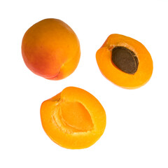 Ripe apricot fruits, one whole and divided into pieces, on a white background in isolation
