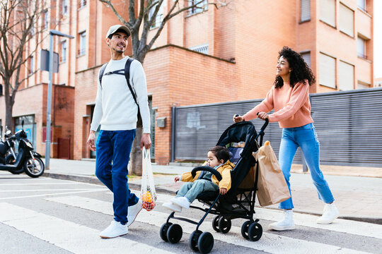 Indian parents with baby crossing road