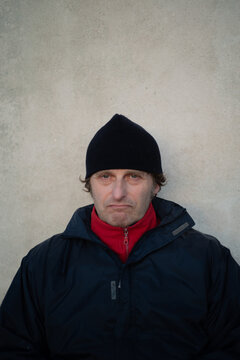 Old man in a beanie with a grumpy expression