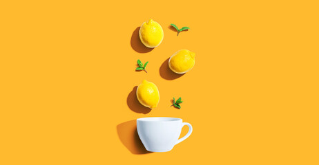 Fresh yellow lemons with tea cup overhead view
