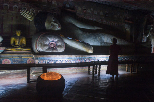 a woman admiring a statue of a resting buddha 
