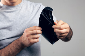 man shows an empty leather wallet.