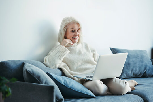 Senior smiling woman using a laptop.