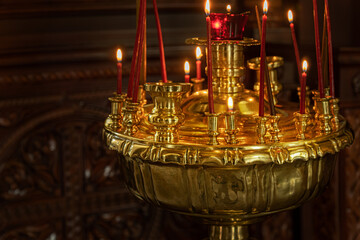 gilded candlestick with burning candles in christian church