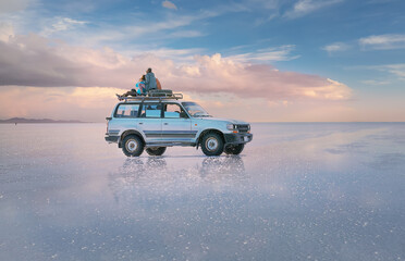 off-road vehicle stands on the salt flat of Uyunu at sunset. Road trip  to Bolivia, South America