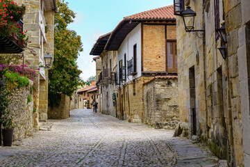 Narrow street with old stone houses and cobblestone pavement. Santillana del Mar.