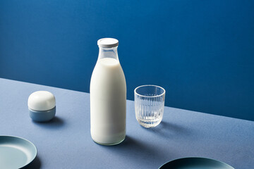 Bottle of milk near container and glass