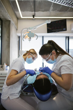 Female nurse helping doctor healing client 