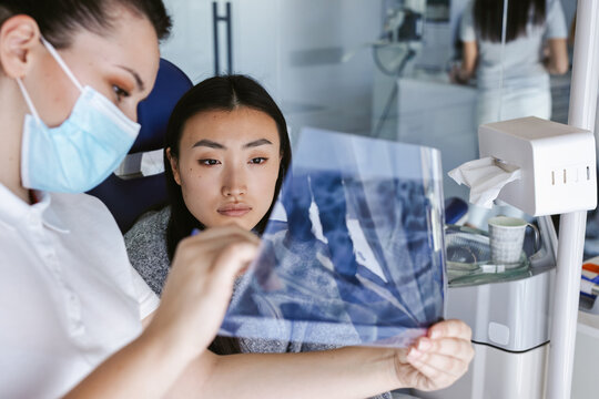 Dentist Analyzing X-Ray Of The Patient