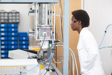 Scientist african american woman work in tech lab with electronic superconducting nanowire single-photon detector. Research and development of electronic devices by black woman.