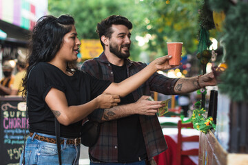 Paying for a healthy juice at an outdoor market stand