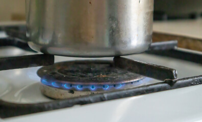 Dirty gas stove in the kitchen for cooking with vegetable oil stains and burnt food debris on the...