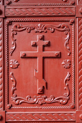 Fragment of the door of the Orthodox Church with a cross and an ornate frame