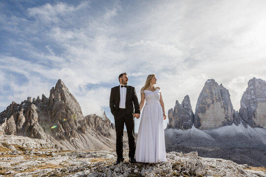 Wedding Couple Holding Hands In Front Of A Dolomity Mountain