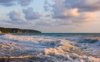 sea landscape is a pebbly beach with waves in white foam