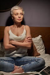 Anxious and nervous woman sitting in bed at night with arms folded, suffering from depression, in despair, worry about problems in life. loneliness, anxiety