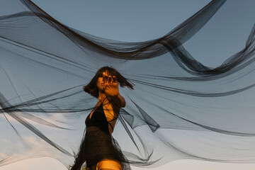 model playing with black tulle fabric