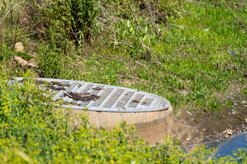 A drain in an outdoor drainage ditch retention pond