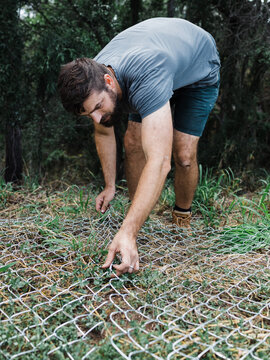 Man splicing fence sections together