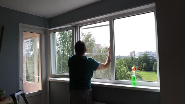 Installation of window screen with mosquito net in residential area. Mature man puts flyscreen in room.