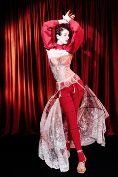 Graceful woman pose on red backdrop