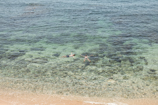 Two friends floating at the beach