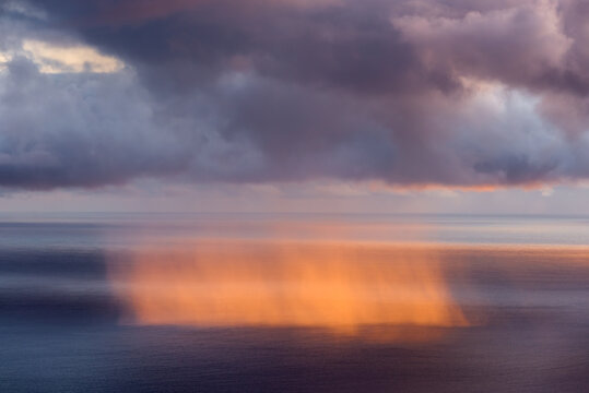 Rain curtain on the sea at sunrise.