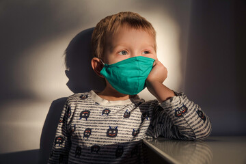 Little boy wearing green fabric face mask