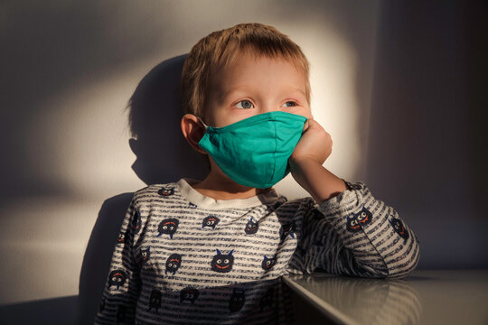 Little boy wearing green fabric face mask