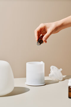 Anonymous person pouring essential oil into diffuser