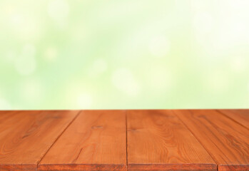 Naklejka na ściany i meble wooden table on green background with defocus light circles and rays