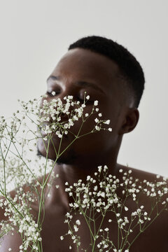 Portrait of an african guy in the cloud of  tiny flowers