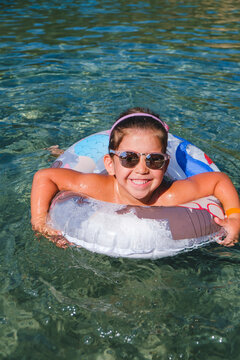 Litle Girl with Colored Lifebuoy in the Sea