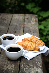 Coffee and croissants on old rustic wooden table