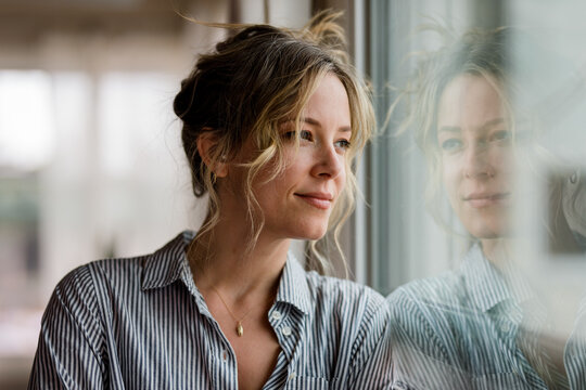 Youthful Woman Stares Boldly Out Her Apartment Window
