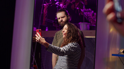 Two adult people are taking a photo on the phone 