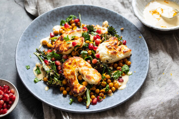 Grilled halloumi cheese with roasted chickpeas, broccollini, tahini sauce and pomegranate