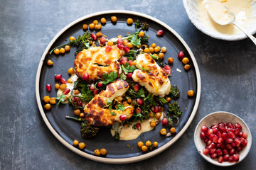 Grilled halloumi cheese with roasted chickpeas, broccollini, tahini sauce and pomegranate