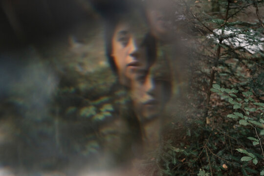 Portrait Of Young Woman In The Forest Looking At Camera Through Prism