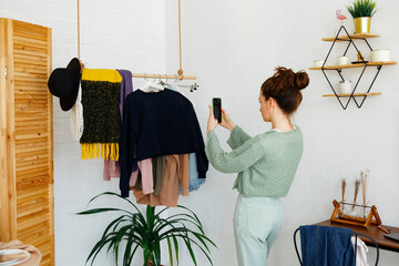 Stylish woman taking photo of clothing at home